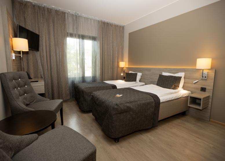Hotellrum med två skilda sängar, fåtöljer