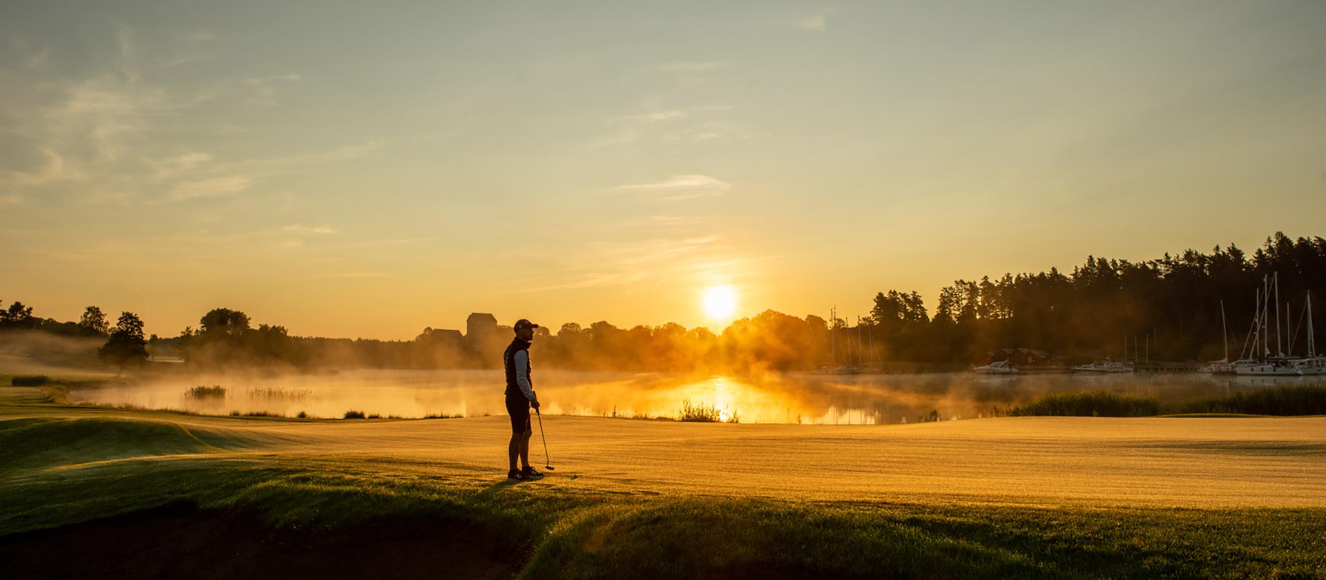 Golfspelare i soluppgången vid Ålands Golfklubb på Åland.