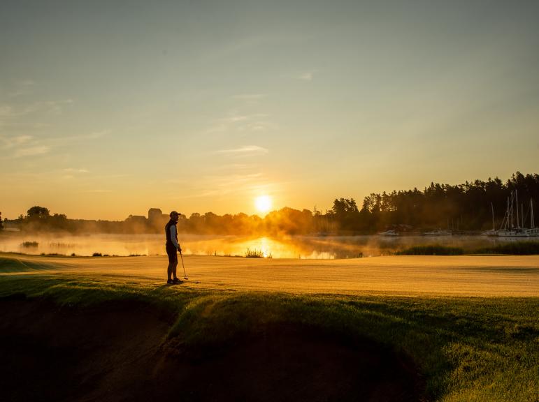Golfspelare i soluppgången vid Ålands Golfklubb på Åland.