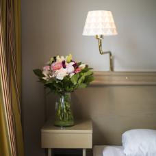 Nattduksbord vid sängen i standardrum vid Hotell Adlon.