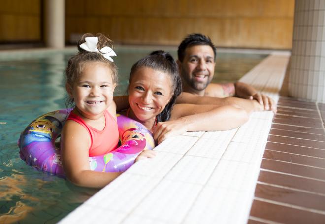 Familj vid poolkanten vid bastu- och poolavdelningen vid Hotell Savoy.